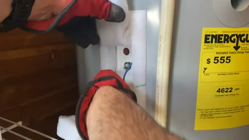 Hands connecting a hose at the lower drain connection of a water heater