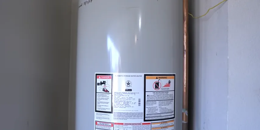 Storage water heater with front safety labels and adjacent copper pipework